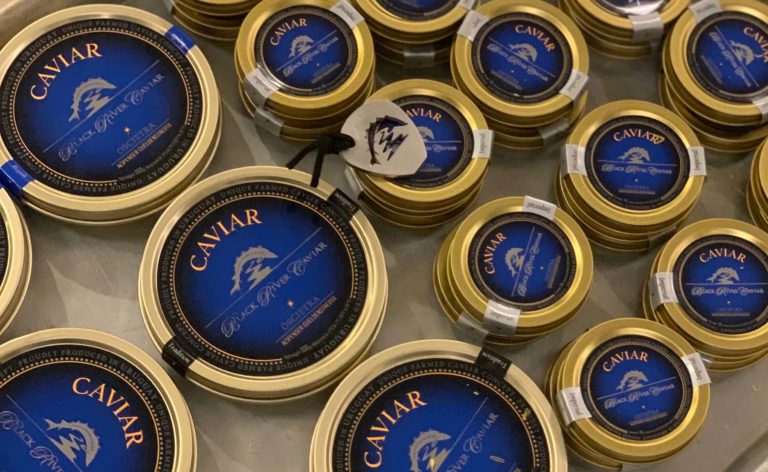 Tins of Black River Caviar on a table.